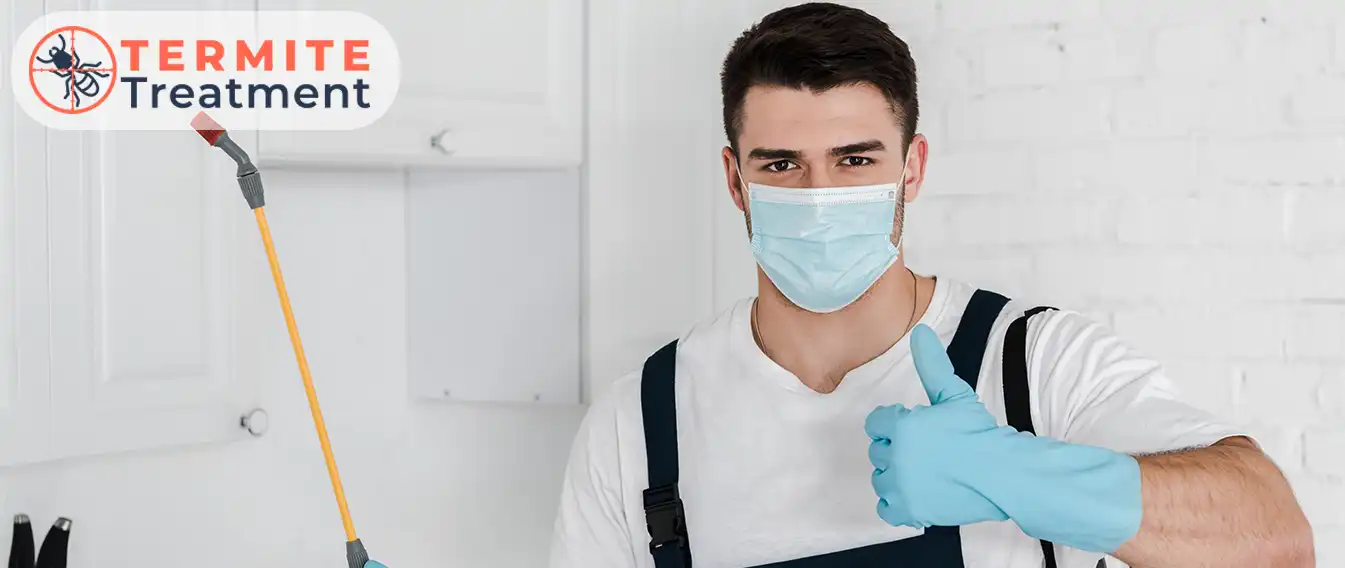 Pest control worker ready for termite treatment, giving a thumbs-up.